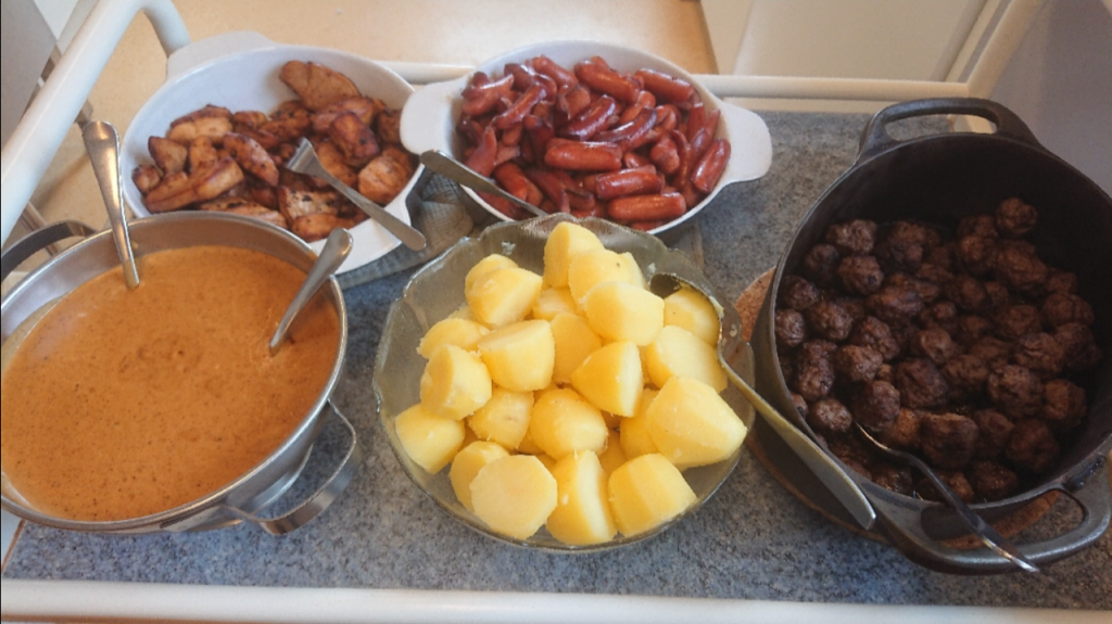 Påsklunch, köttbullar, korv, potatis och sås.